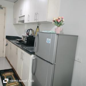 Il comprend une cuisine équipée d'un réfrigérateur et d'un vase de fleurs. dans l'établissement Sea Residences Tower E&B - AURUM, à Manille