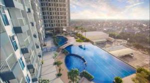 a view of a swimming pool in a building at 2 BR I ANDERSON I 22floor I above pakuwon mall I the biggest shopping center in Surabaya