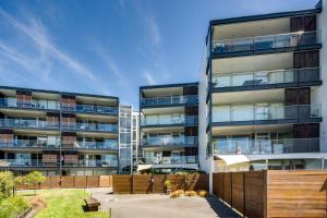 an apartment building with a fence in front of it at The Bay Bach - Napier Holiday Apartment in Napier