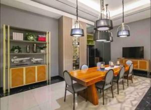 a dining room with a wooden table and chairs at 2 BR I ANDERSON I 22floor I above pakuwon mall I the biggest shopping center in Surabaya