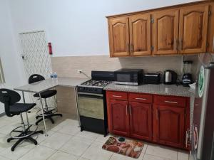 a kitchen with wooden cabinets and a stove top oven at La Rose Apartment in Montego Bay +13 photos