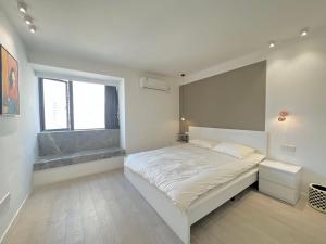 a white bedroom with a bed and a window at Shanghai Jing'an Temple Quality 3 bedrooms Alarming and quiet Commercial area Convenient transportation in Shanghai