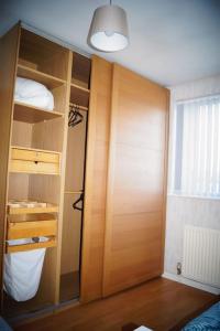Cette chambre comprend un placard avec une porte en bois. dans l'établissement 3 Bed House with Exceptional view, à Batley