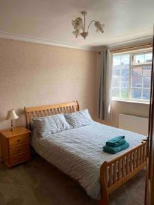 a bedroom with a bed and a lamp and a window at 3 Bed House with Exceptional view in Batley