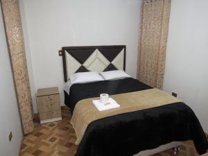 Un dormitorio con una cama con una toalla. en Hospedaje EL RINCONCITO II, en Jauja