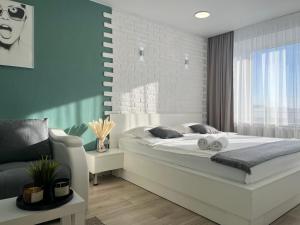 um quarto com uma grande cama branca e uma cadeira em Апартаменты с видом на город em Pavlodar