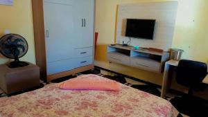 Schlafzimmer mit einem Bett und einem Flachbild-TV in der Unterkunft Riverside house in Barra dos Coqueiros