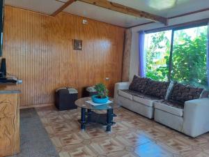 uma sala de estar com um sofá e uma mesa em Cabañas Hare Tupuna o Piri Nui em Hanga Roa
