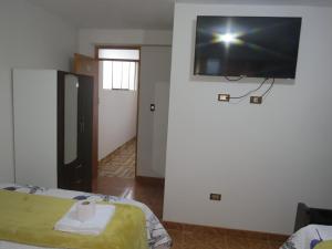 a room with a flat screen tv on the wall at Hospedaje EL RINCONCITO II in Jauja
