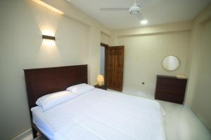a bedroom with a large white bed and a mirror at BNB RESIDENCIES MOUNT LAVINIA 2 in Mount Lavinia