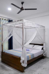 una cama con dosel en una habitación en Nirwana Villa, en Mirissa