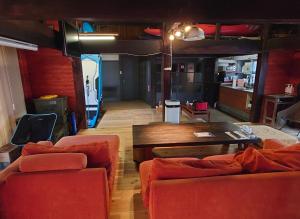 een woonkamer met 2 oranje banken en een tafel bij Guesthouse Tide Pool - Vacation STAY 62386v in Amakusa