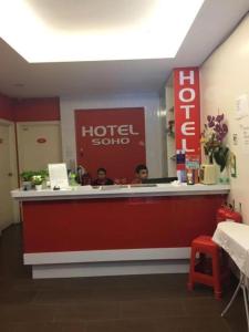 dos personas sentadas en un mostrador de hotelaho en un restaurante en NEW D SOHO HOTEL GOMBAK en Batu Caves