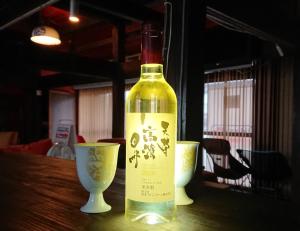 a bottle of wine sitting on a table with two cups at Guesthouse Tide Pool - Vacation STAY 62386v in Amakusa