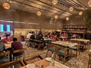 プネにあるMango Leaf Lake Resortのレストランの席に座る人々