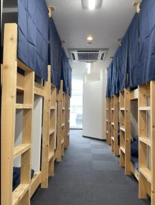 um corredor de um quarto com prateleiras de madeira em 広島ゲストハウス Nice Day em Hiroshima