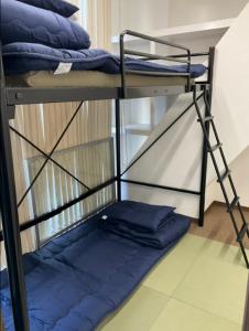 - łóżko piętrowe na poziomie z niebieskimi poduszkami w obiekcie 広島ゲストハウス Nice Day w mieście Hiroszima