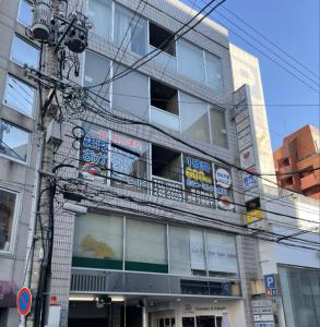 budynek z mnóstwem znaków na boku w obiekcie 広島ゲストハウス Nice Day w mieście Hiroszima