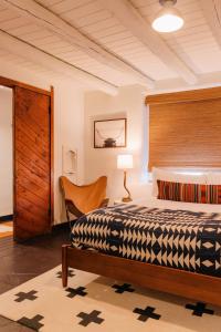 a bedroom with a bed and a chair in a room at Pueblo Bonito Inn in Santa Fe