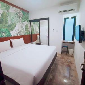 Nunia Tamansari Hotel في Kumprung: غرفة نوم مع سرير أبيض كبير في غرفة