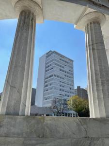a tall building with two columns in front of it at Carso Alameda Premium Apartments in Mexico City