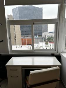 a desk in front of a window with a view of a city at Carso Alameda Premium Apartments in Mexico City