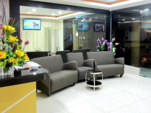 a waiting room with couches and flowers on the wall at RG Grand Hotel in Parit Raja