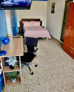 Schlafzimmer mit einem Bett, einem Schreibtisch und einem Schreibtisch in der Unterkunft Habitación en Chiclayo in Chiclayo