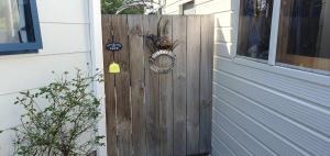a wooden door with a bee on it next to a house at Moe Marie Sleep Peacefully in Turangi