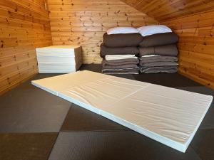 una habitación con una cama y un montón de ropa en Pension Tomato en Hakuba