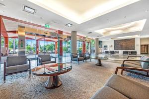 a lobby with chairs and tables in a building at Elegant Harbourside Comfort with Alfresco Patio in Darwin