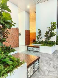 un hall avec des plantes et un banc en bois dans l'établissement Chambers Residence KLCC By Castle, à Kuala Lumpur