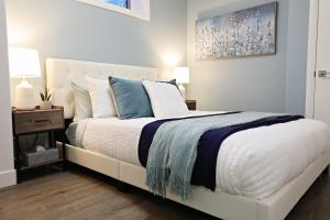 a bedroom with a white bed with blue and white pillows at Queen Bed,Near Airport,Kids Playground,Disney+ in Edmonton