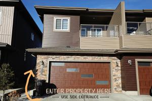 a house with a garage door and a building at Queen Bed,Near Airport,Kids Playground,Disney+ in Edmonton