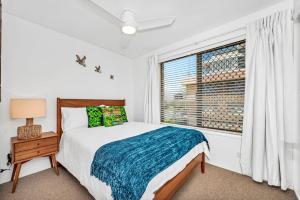 a bedroom with a bed and a window at Lou's Tiki Pad in Gold Coast