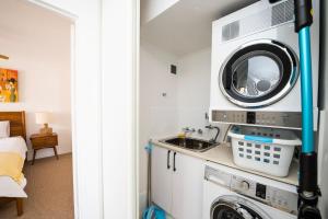 a laundry room with a sink and a washing machine at Lou's Tiki Pad in Gold Coast