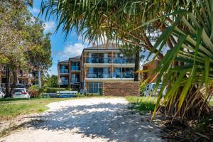 a house with a palm tree in front of it at Lou's Tiki Pad - Beachfront Bilinga North Kirra - Min. 2 Night Stays! in Gold Coast