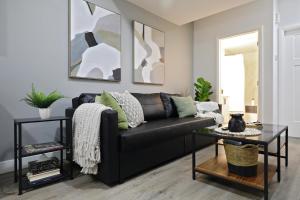 a living room with a black couch and a table at Queen Bed,Near Airport,Kids Playground,Disney+ in Edmonton +22 photos