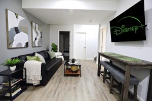 a living room with a black couch and a table at Queen Bed,Near Airport,Kids Playground,Disney+ in Edmonton