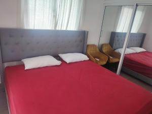 um quarto com 2 camas e um cobertor vermelho em Hermosa Villa en punta cana em Punta Cana