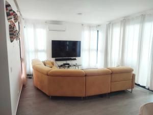 sala de estar con sofá y TV de pantalla plana en Hermosa Villa en punta cana, en Punta Cana
