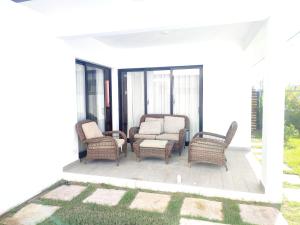 um pátio com cadeiras de vime e um sofá em Hermosa Villa en punta cana em Punta Cana