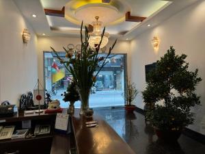 - un bureau avec un bureau orné d'arbres et d'un lustre dans l'établissement Red Building - Hotel - Hà Nội, à Hanoï
