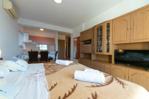 a large bedroom with a large bed and a tv at Apartments Marko - amazing sea view in Brela