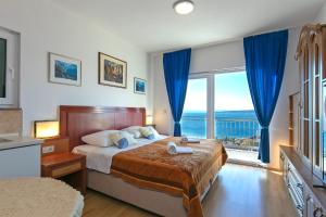 a bedroom with a bed and a large window at Apartments Marko - amazing sea view in Brela