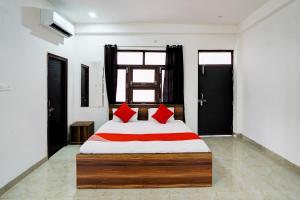 um quarto com uma cama com almofadas vermelhas em OYO Flagship Nakshatram Palace em Kanpur
