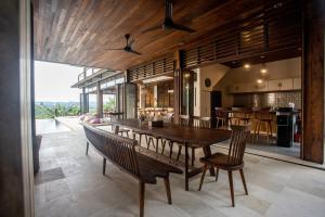 een eetkamer met een grote houten tafel en stoelen bij Villa Sorgas in Kuta Lombok