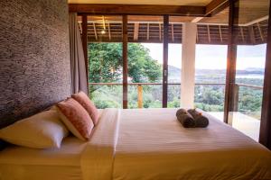 a bedroom with a bed with a large window at Villa Sorgas in Kuta Lombok