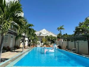 a swimming pool with two swans in a house at Pharos Guesthouse in Mui Ne