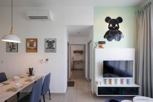 een eetkamer met een teddybeer aan de muur bij Bear Paw Retreat Cityview Apartment Amber Cove in Melaka
